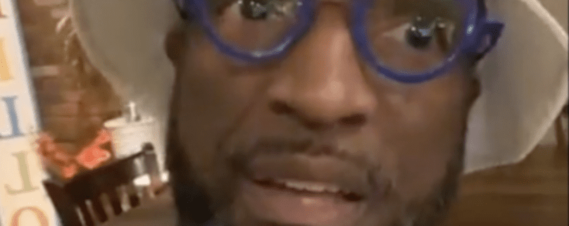 Man wearing blue glasses and hat indoors.